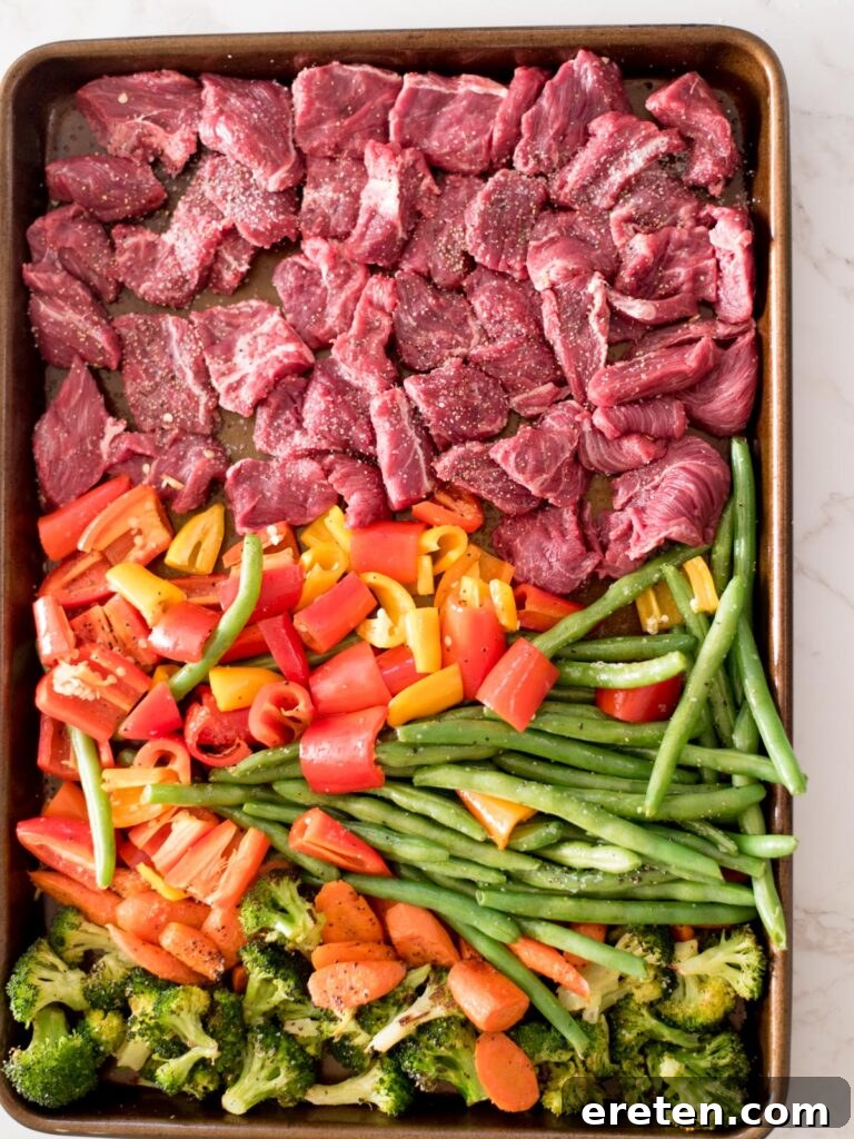 broccoli, carrots, green beans, bell pepper, and beef on a sheet pan