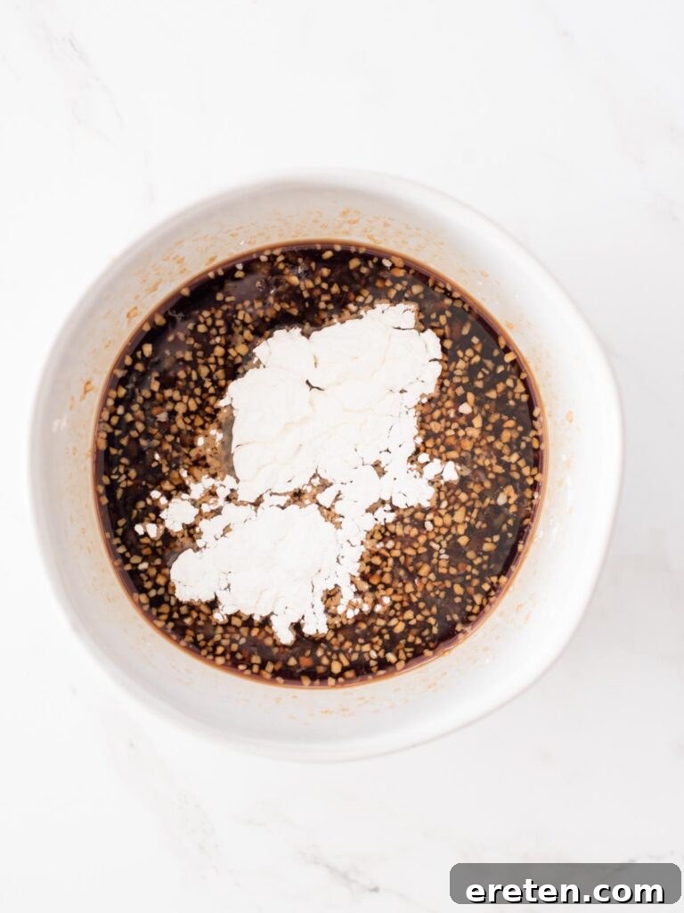 corn starch added to soy sauce in a bowl