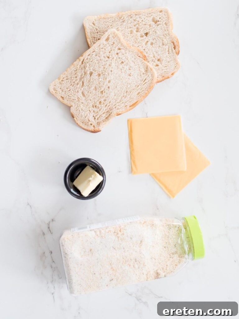 Air Fryer Grilled Cheese Perfection 3 All the essential ingredients neatly arranged on a counter for making an air fried grilled cheese sandwich: slices of bread, a stick of butter, a jar of garlic salt, and thin slices of American cheese.