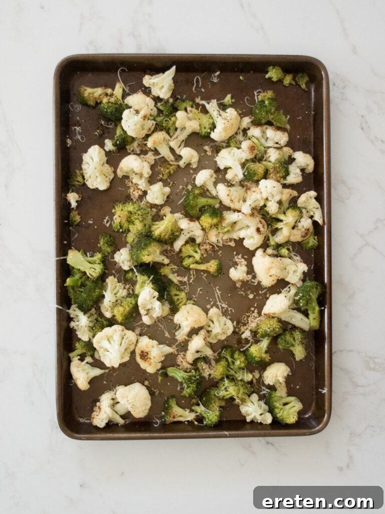 Roasted garlic parmesan cauliflower and broccoli emerging from the oven, golden and fragrant.