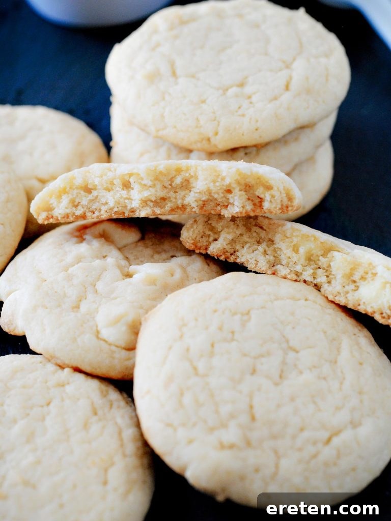 Heavenly Cheesecake Cookies 3 Broken cheesecake cookies stacked, revealing their soft interior and studded with white chocolate chips, a testament to their quick and easy preparation.
