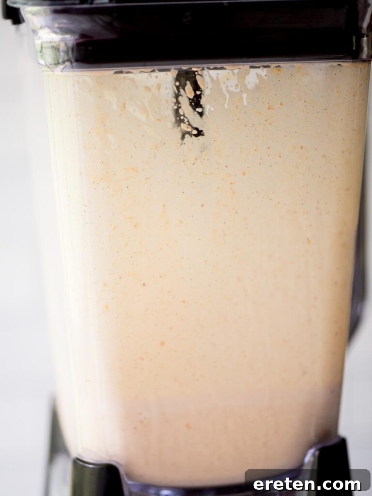 A creamy, perfectly blended pumpkin milkshake swirling in the blender, ready to be poured and served.