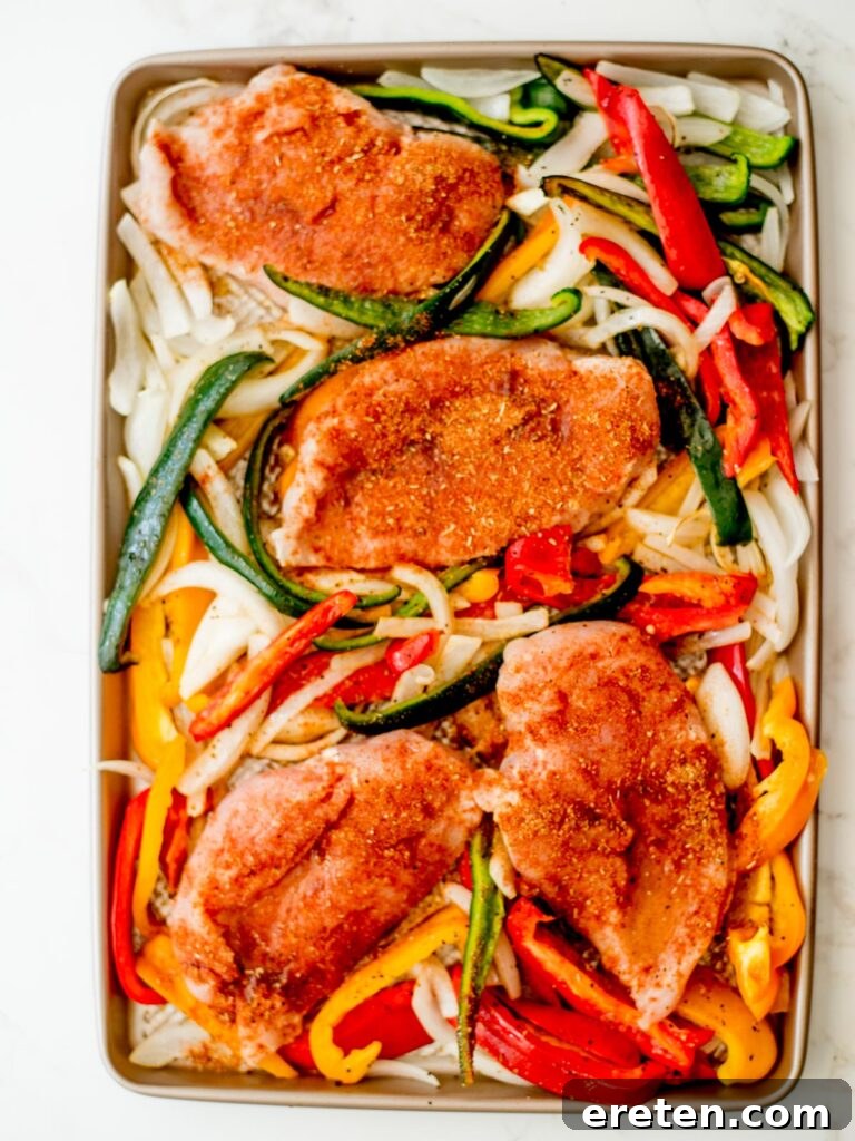 One Pan Chicken Fajita Dinner 6 seasoned chicken added to the sheet pan