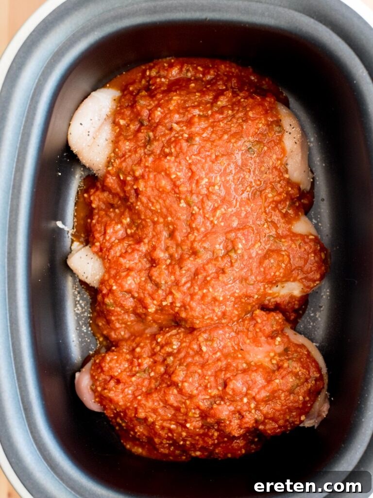Slow Cooker Salsa Chicken with Melted Queso 5 seasoned chicken with salsa in crockpot sleeve