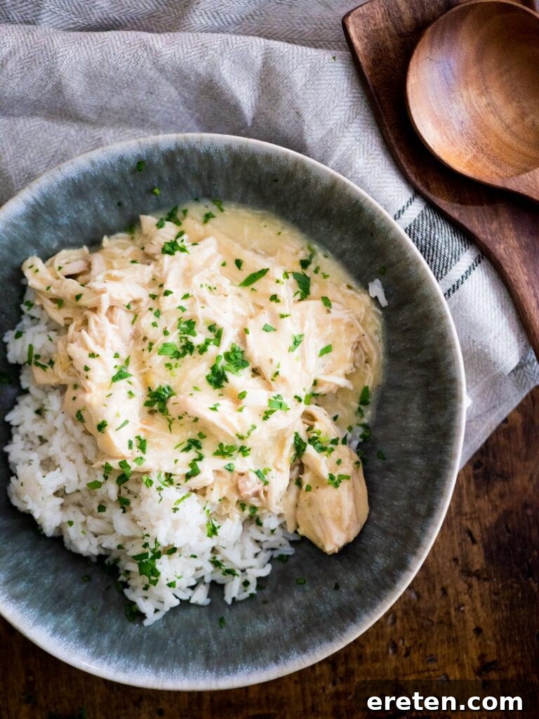 Creamy Ranch Slow Cooker Chicken 2 Delicious Crockpot Ranch Chicken served over a bed of fluffy white rice, garnished with fresh parsley.