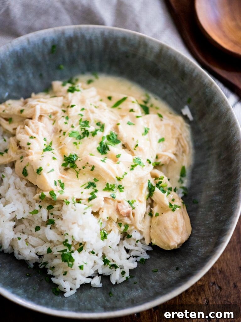 Creamy Ranch Slow Cooker Chicken 8 Close-up of Crockpot Ranch Chicken served over rice, garnished with fresh parsley, highlighting its creamy texture.