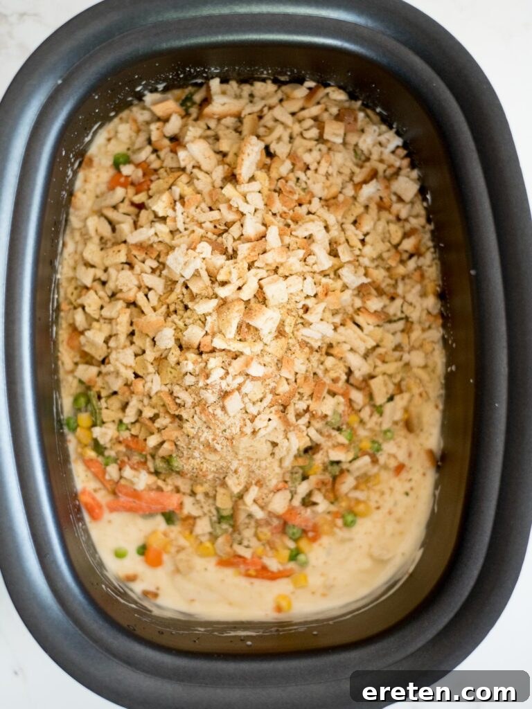 Dry stuffing mix being poured into the crockpot, ready to be combined with the other ingredients.