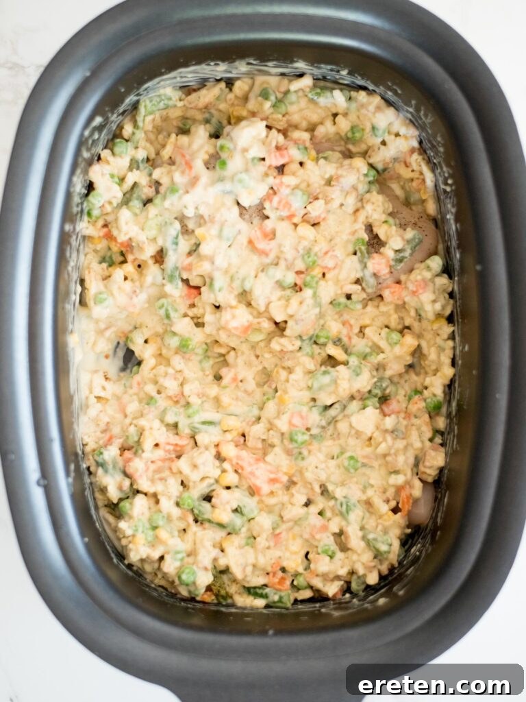 The uncooked chicken and stuffing casserole, fully assembled and ready for the slow cooking process in the crockpot.