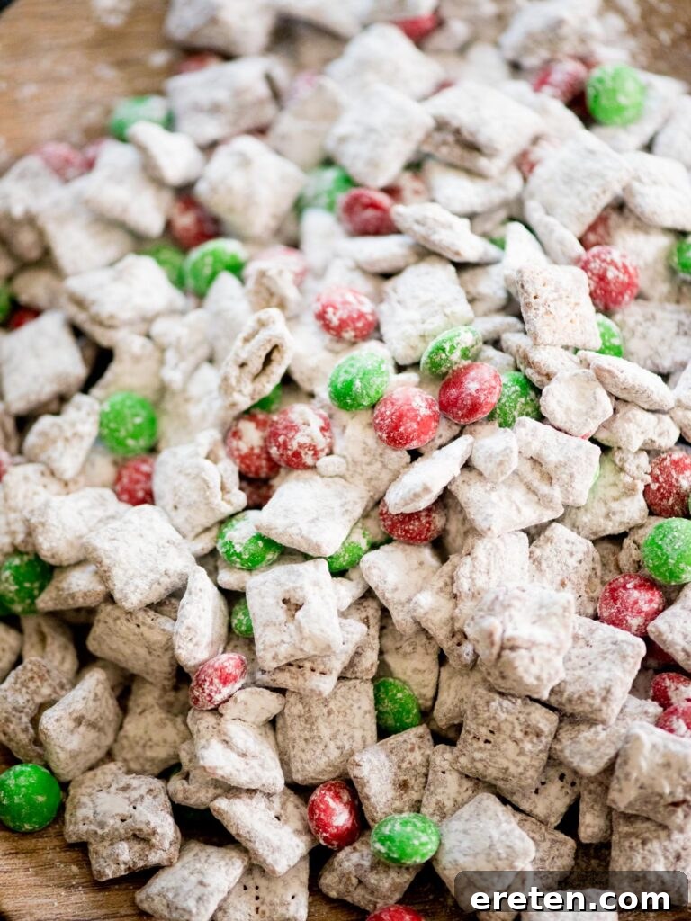 Festive Homemade Muddy Buddies 10 Close-up of the finished muddy buddies recipe, featuring the vibrant green and red M&Ms, illustrating its festive appeal.