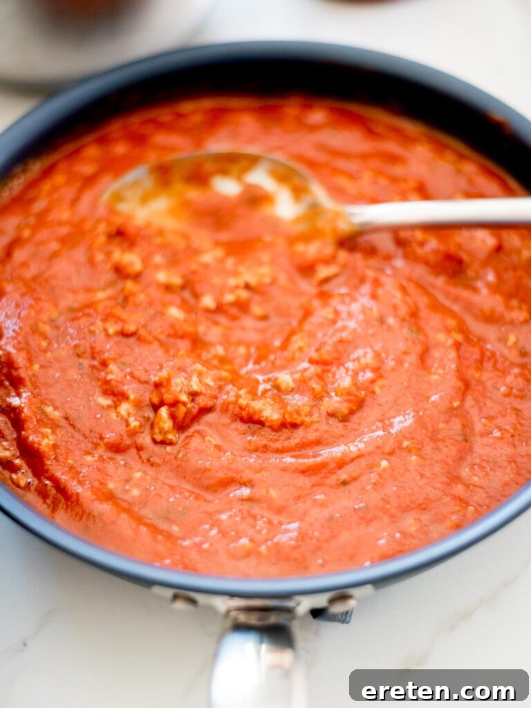 pasta sauce and italian sausage mixed together in a skillet