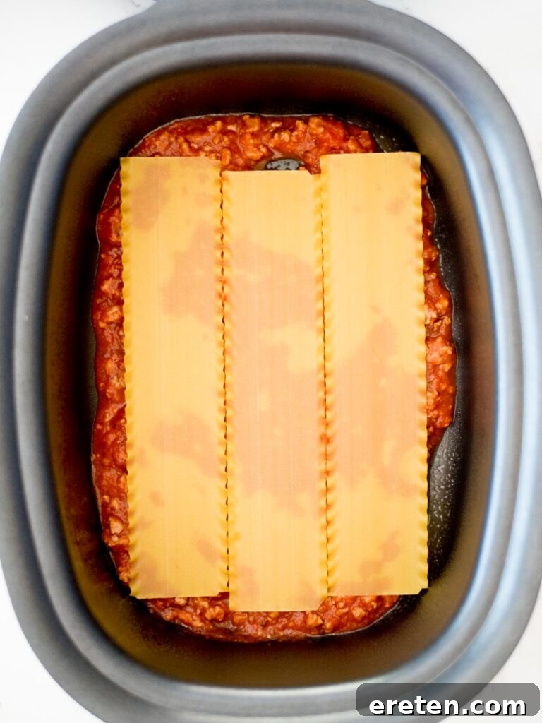 noodles on top of sauce in the crockpot