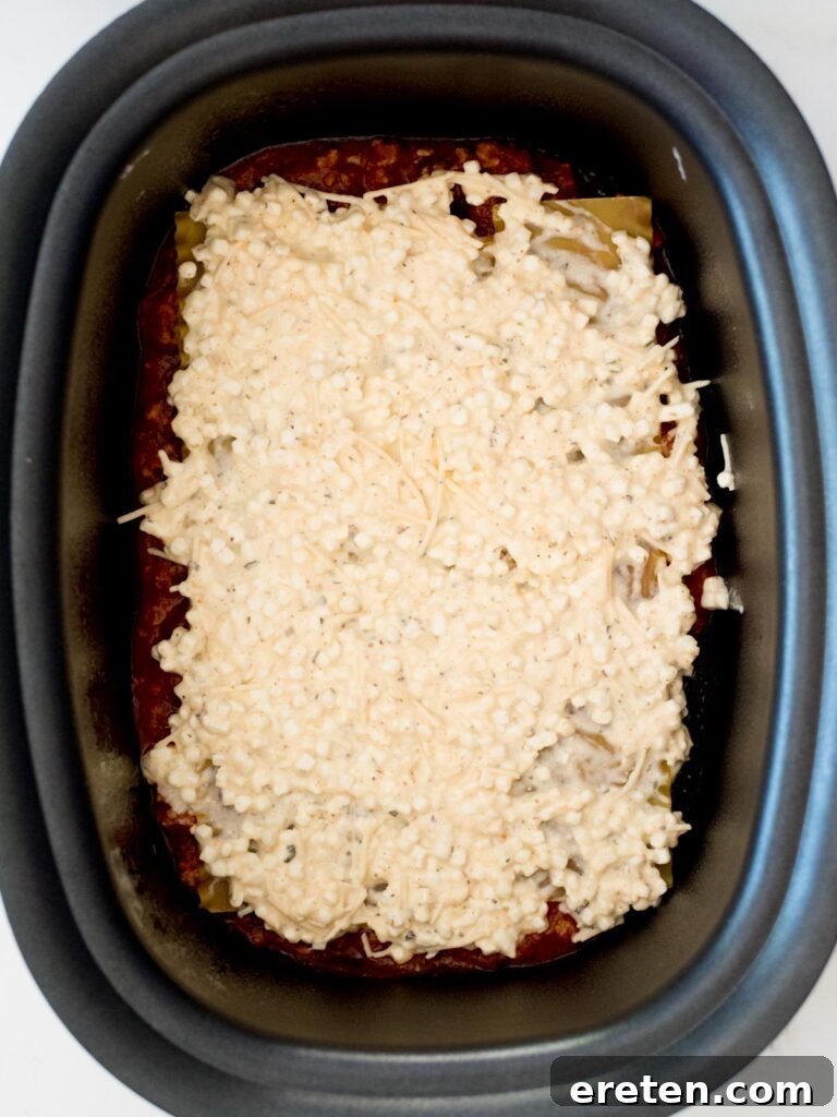 cheese mixture on top of noodles in the crockpot