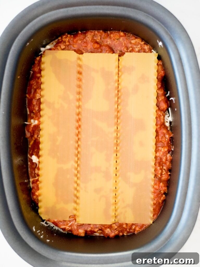 noodles on top of sauce in the crockpot