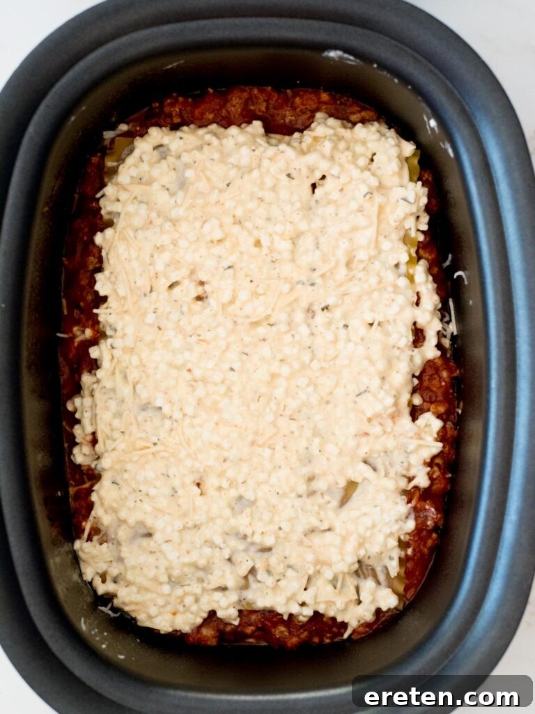 cheese mixture on top of noodles in the crockpot