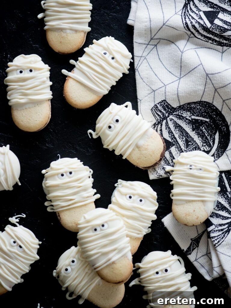 Stacked mummy cookies with candy eyes, ready for a Halloween party