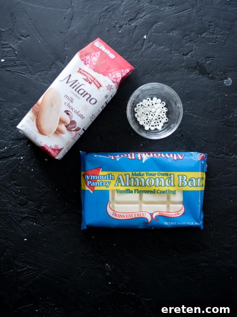 Ingredients for making mummy cookies: Milano cookies, almond bark, and mini candy eyes laid out on a surface