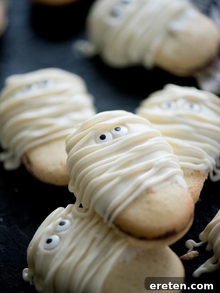 Stacked mummy cookies with candy eyes, ready to be served
