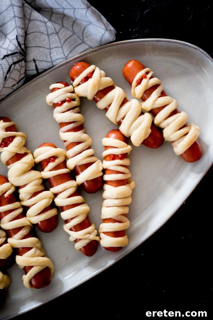Halloweenie Mummies 6 Multiple mummy pigs in a blanket artfully arranged on a serving tray, garnished and ready for guests