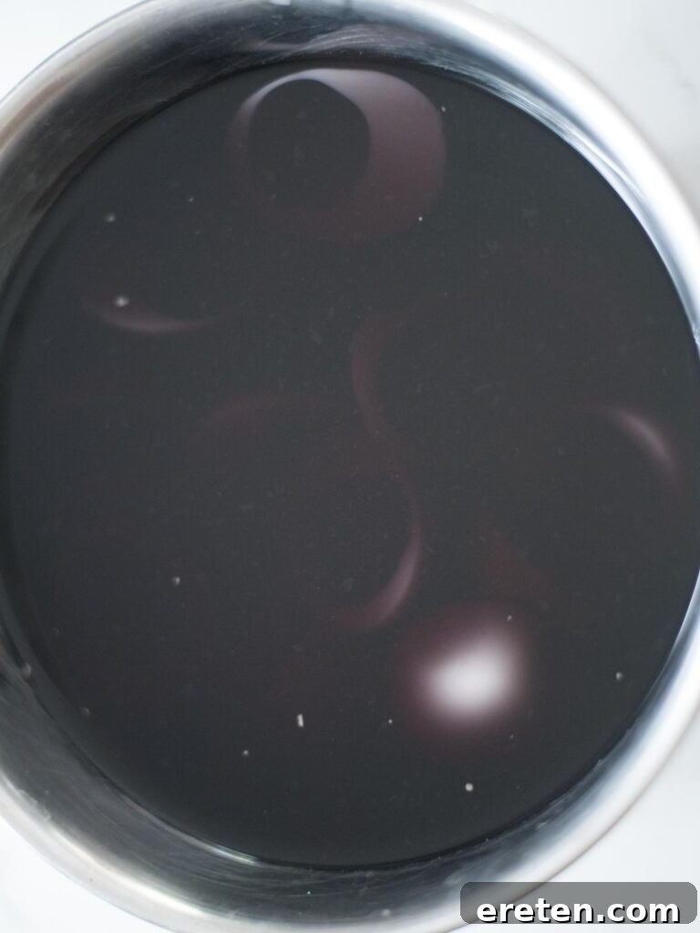 Hard-boiled egg whites soaking in a mixing bowl with blue and red food coloring, turning purple.