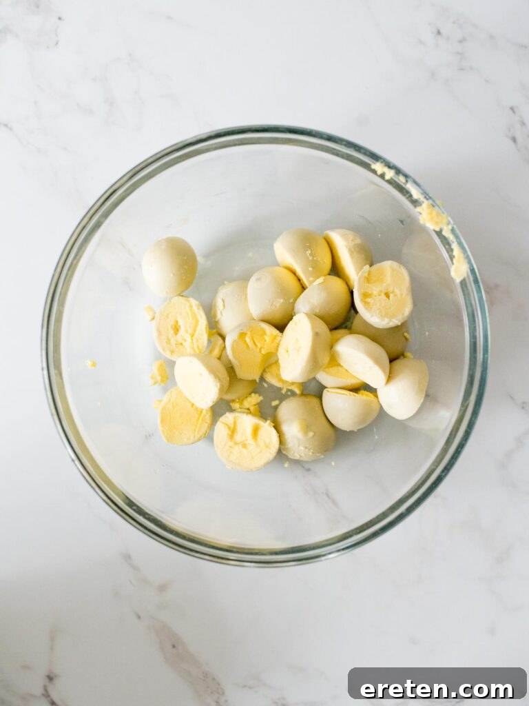 Hard-boiled egg yolks in a mixing bowl, mashed and ready for additional ingredients to create the filling.