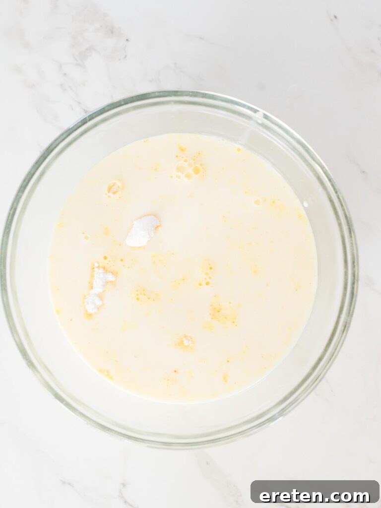 Cold milk being added to the instant pudding mix in a mixing bowl.