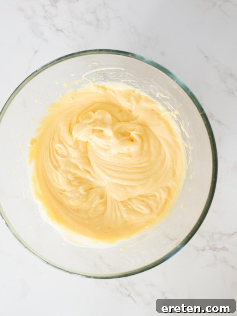 The rich and creamy pudding, cream cheese, and sweetened condensed milk mixture fully combined in a mixing bowl.