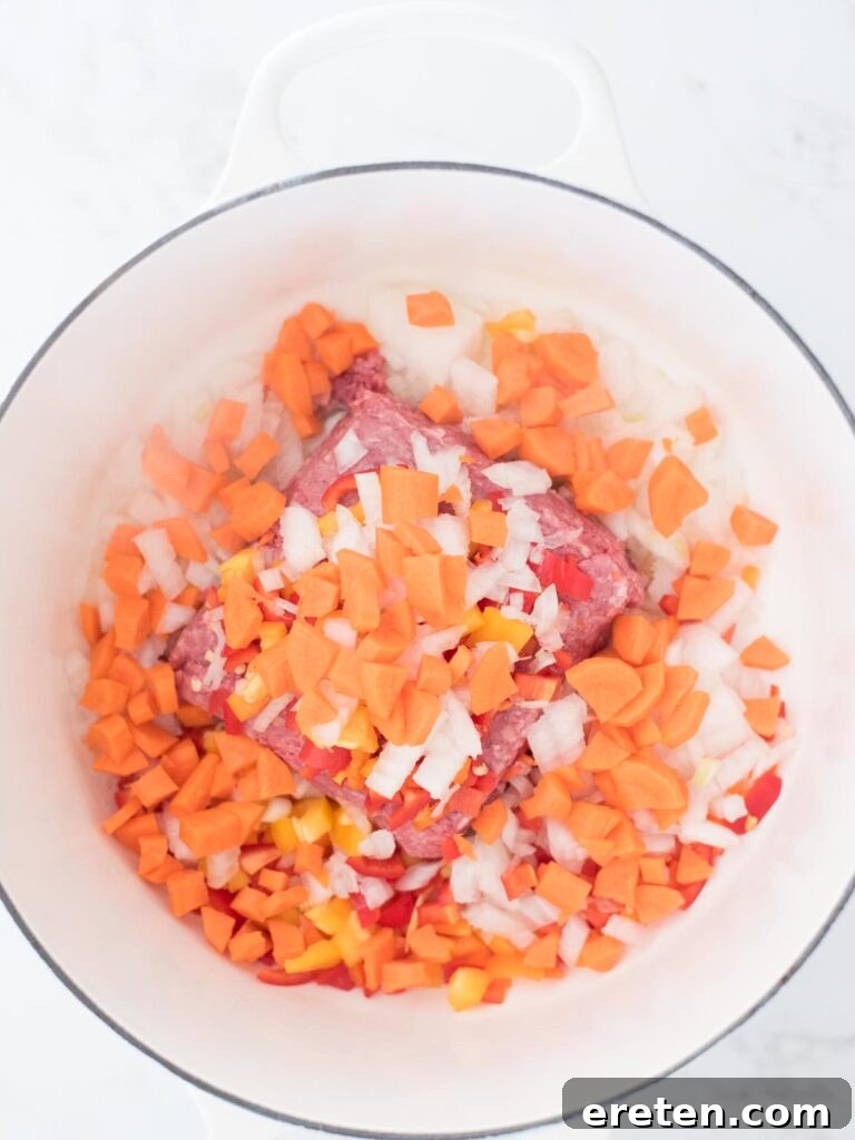 Peeled and chopped carrots introduced to the pot, adding sweetness and texture to the chili base.